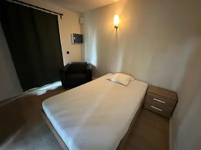 a small room with a bed and a chair at Woodboxcabins - Campinggroenpark in Zele