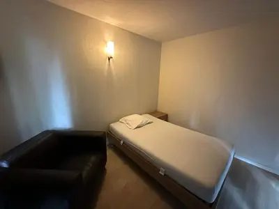 a small room with a bed and a couch at Woodboxcabins - Campinggroenpark in Zele