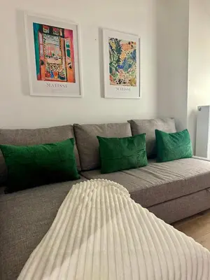 a couch with green pillows in a living room at The Central Experience - 2 BR, Bright, Spacious & Central in Brussels