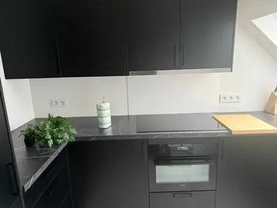a kitchen with black cabinets and a plant on the counter at The Central Experience - 2 BR, Bright, Spacious & Central in Brussels