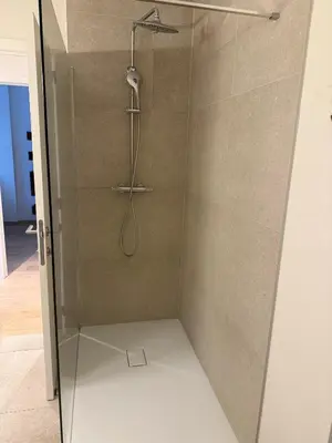 a shower with a shower head and a glass door at The Central Experience - 2 BR, Bright, Spacious & Central in Brussels