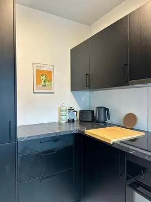 a kitchen with black cabinets and a counter top at The Central Experience - 2 BR, Bright, Spacious & Central in Brussels
