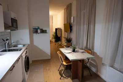 a small kitchen with a table and chairs in a room at Studio 1 Cosy Avenue Louise in Brussels