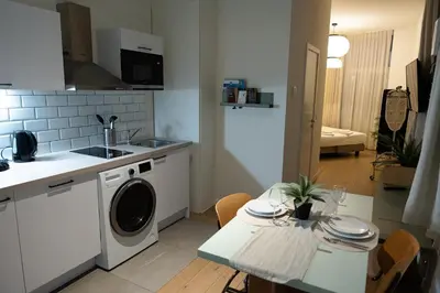 a kitchen with a washing machine and a table with chairs at Studio 1 Cosy Avenue Louise in Brussels