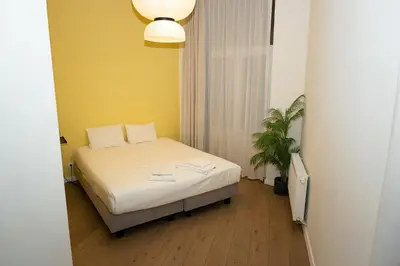 a small room with a bed and a plant at Studio 1 Cosy Avenue Louise in Brussels