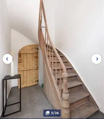 a staircase in a house with a wooden door at Groot rustgevend huis met dakterras uitzicht op het groen kwartier van Berchem in Antwerp
