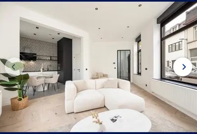 a living room with a white couch and a table at Groot rustgevend huis met dakterras uitzicht op het groen kwartier van Berchem in Antwerp