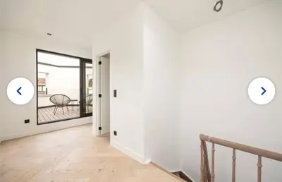 a hallway with a staircase and a room with white walls at Groot rustgevend huis met dakterras uitzicht op het groen kwartier van Berchem in Antwerp