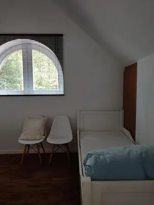 a bedroom with a bed and a window and two chairs at De Steeg in Kalmthout