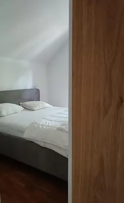 a bed with white sheets and pillows in a bedroom at De Steeg in Kalmthout