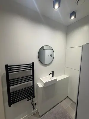 a white bathroom with a sink and a mirror at Luxury Apartment Antwerp Port Moerbeke 2 in Lokeren