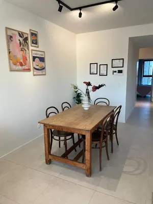 a wooden dining room table with chairs and a vase with flowers at Luxury Apartment Antwerp Port Moerbeke 2 in Lokeren