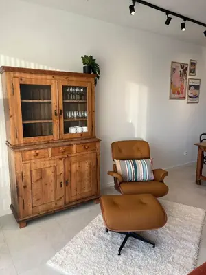 a living room with a chair and a cabinet at Luxury Apartment Antwerp Port Moerbeke 2 in Lokeren