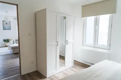 a bedroom with white cabinets and a mirror at Lovely 1BR & 1LR Apt for 4P, Only 15 Min Walk to City Center in Ghent
