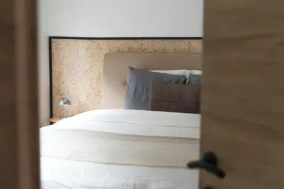 a bedroom with a large white bed with a mirror at Lovely 1BR & 1LR Apt for 4P, Only 15 Min Walk to City Center in Ghent