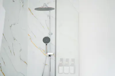 a shower with a shower head in a bathroom at Lovely 1BR & 1LR Apt for 4P, Only 15 Min Walk to City Center in Ghent