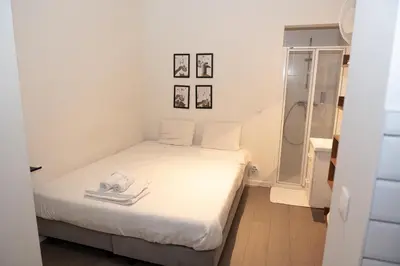 a small bedroom with a bed and a shower at Studio 003 Avenue Louise in Brussels