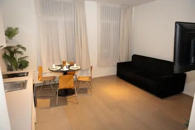 a living room with a black couch and a table at Studio 003 Avenue Louise in Brussels