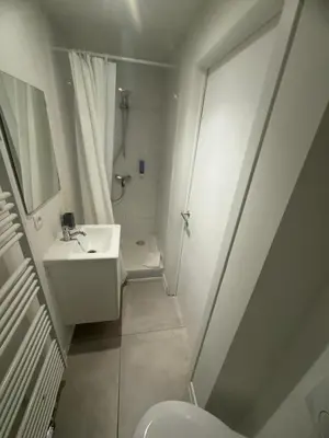 a white bathroom with a sink and a toilet at Studio 003 Avenue Louise in Brussels