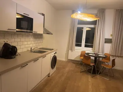 a kitchen with a sink and a table with chairs at Studio 003 Avenue Louise in Brussels