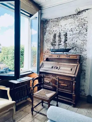 a wooden piano in a room with a window at Legions Suite in Antwerp