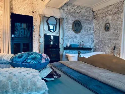 a bedroom with a bed and a tub and a sink at Legions Suite in Antwerp