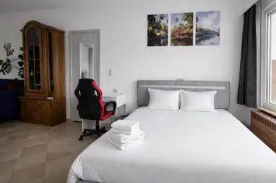 a bedroom with a bed and a desk and a chair at cozy studio Brussels airport in Steenokkerzeel