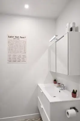 a white bathroom with a sink and a mirror at cozy studio Brussels airport in Steenokkerzeel