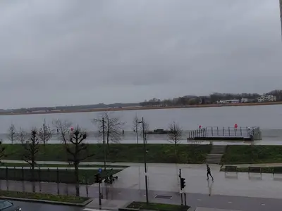 a flooded street with a body of water with a pier at 3 units - Logies De Lelie in Antwerp