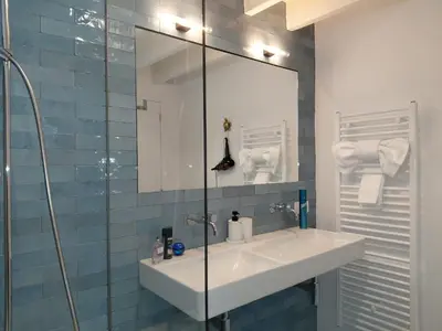 a bathroom with a sink and a glass shower at 3 units - Logies De Lelie in Antwerp