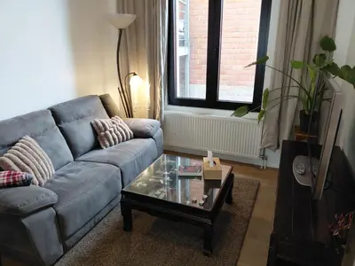 a living room with a blue couch and a coffee table at 3 units - Logies De Lelie in Antwerp
