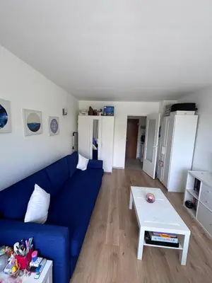a living room with a blue couch and a table at Studio Blueberry in Brussels