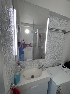 a person taking a picture of a bathroom with a sink at Studio Blueberry in Brussels