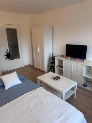 a room with a bed and a table and a tv at Studio Blueberry in Brussels