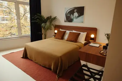 a bedroom with a bed and a desk and a window at A Place - Boutique Hotel - Meir 24 in Antwerp