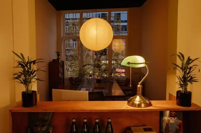 a desk with a lamp and a table with bottles at A Place - Boutique Hotel - Meir 24 in Antwerp