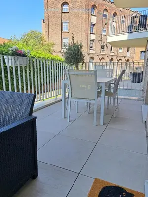 a patio with a table and chairs on a balcony at Casa Kim in Willebroek