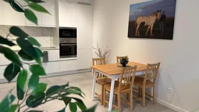 a kitchen with a table and chairs and a horse painting on the wall at Casa Kim in Willebroek