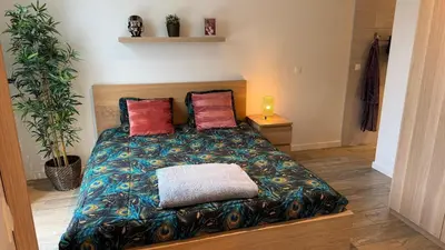 a bedroom with a bed with a blanket and two pillows at Casa Kim in Willebroek