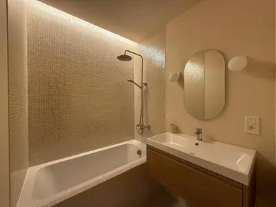 a bathroom with a tub and a sink and a mirror at European Smart Studio in Brussels