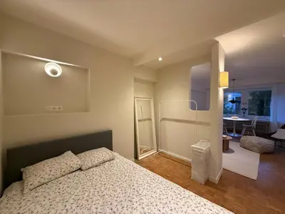 a bedroom with a bed and a living room at European Smart Studio in Brussels