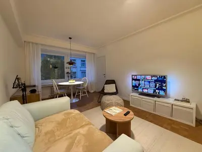 a living room with a couch and a flat screen tv at European Smart Studio in Brussels