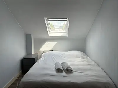 a bedroom with a bed with two slippers on it at Charming Entire Apartment in Saint-Gilles, Brussels in Brussels
