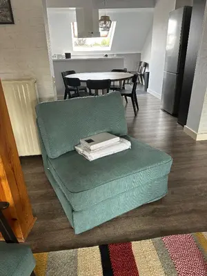 a living room with a green couch and a table at Charming Entire Apartment in Saint-Gilles, Brussels in Brussels