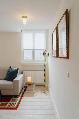 a living room with a couch and a mirror at Cozy Apartment in Central Antwerp in Antwerp
