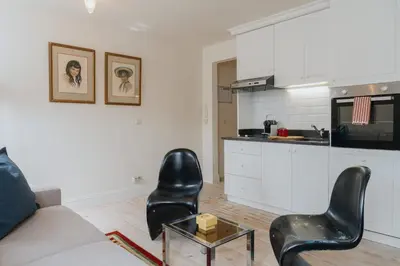 a living room with a couch and chairs and a kitchen at Cozy Apartment in Central Antwerp in Antwerp