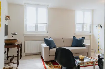 a living room with a couch and two windows at Cozy Apartment in Central Antwerp in Antwerp