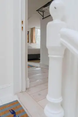 a white hallway with a bed in a bedroom at Cozy Hideaway Near the Heart of Antwerp in Antwerp