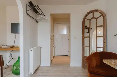a living room with a hallway with a mirror at Cozy Hideaway Near the Heart of Antwerp in Antwerp