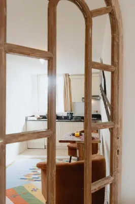 a kitchen with a table and a mirror at Cozy Hideaway Near the Heart of Antwerp in Antwerp